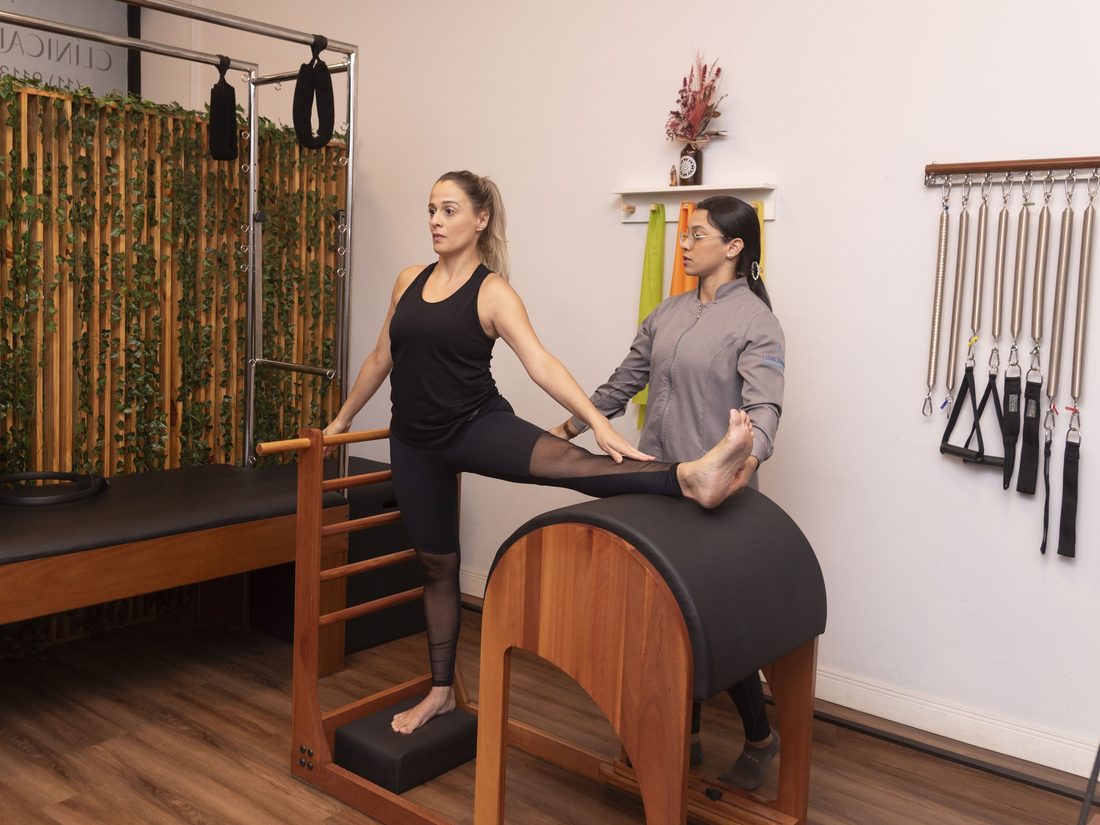 Turma pequena de pilates em exercício com acompanhamento da professora